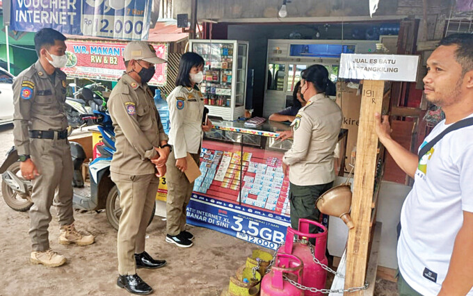 SOSIALISASI: Kabid Binmas Satpol PP Palangka Raya Meri Kristin bersama anggota saat menyampaikan SK Wali Kota Palangka Raya tentang penetapan HET elpiji 3 kilogram kepada pengecer di sekitar Jalan Bukit Keminting, Rabu (26/4).