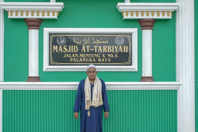 MENJAGA RUMAH IBADAH: Rajudinor Marbut Masjid At-Tarbiyah saat membuka pintu masjid. ARIEF PRATHAMA/KALTENG POS