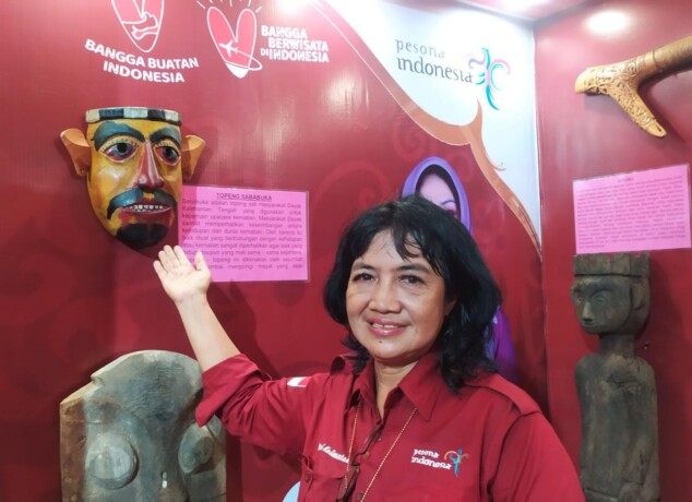 KOLEKSI MUSEUM: Budayawan Yemina Yulita tengah memperlihatkan salah satu koleksi museum balanga, yakni topeng sababuka yang ditampilkan dalam pameran Kalteng Expo 2023, Sabtu (20/5). AKHMAD DHANI/KALTENG POS