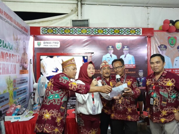 MENGUMUMKAN: Sekretaris Dinas Pemberdayaan dan Desa (PMD) Kalteng Etty Aprilya mengumumkan peserta yang mendapat hadiah di Stan Dinas PMD Kalteng pada penutupan Kalteng Expo 2023, Minggu (21/5).  (FOTO: DINAS PMD UNTUK KALTENG POS)