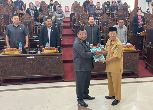 SEPAKAT: Ketua DPRD Kapuas, Ardiansah, dan Pelaksana Tugas (Plt) Bupati Kapuas, HM. Nafiah Ibnor, menunjukkan dokumen raperda saat rapat paripurna, Selasa (13/6).