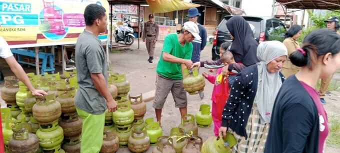 OPSAR: Masyarakat setempat menukarkan elpiji nya kepada petugas dalam operasi pasar elpiji 3kg, Selasa (20/6). ILHAM ROMADHONA/ KALTENG POS