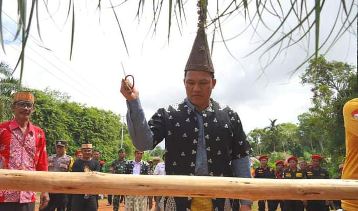 DI BATU TAMBUN : Bupati Lamandau H Hendra Lesmana memotong pantan saat kunjungan ke Desa Batu Tambun, Kecamatan Batang Kawa, sekaligus memberikan bantuan kepada warga setempat, Rabu (7/6). FOTO : HUMAS UNTUK KALTENG POS