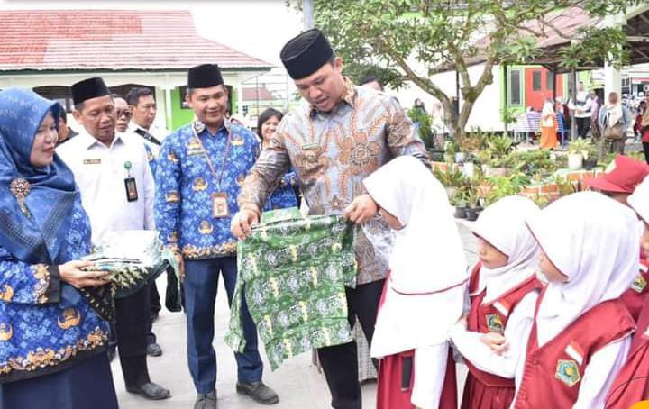 BANTU SERAGAM SEKOLAH : Bupati Lamandau H Hendra Lesmana menyerahkan bantuan seragam sekolah batik kepada sejumlah pelajar di Kota Nanga Bulik, belum lama ini.HUMAS UNTUK KALTENG POS