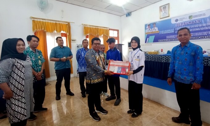 MATERI PELATIHAN : Kepala Disnakertranskop UKM Barito Utara M Mastur didampingi BPJS Tenaga Kerja Surya dan sejumlah kepala bidang menyerahkan materi pelatihan kepada salah satu peserta secara simbolis di BLK setempat, Kamis (13/7).