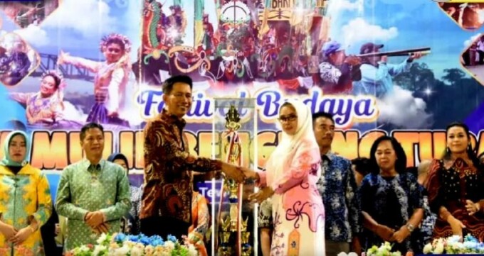 PEMBUKAAN : Bupati Barito Utara H Nadalsyah menyerahkan piala bergilir kepada Ketua Panitia Pelaksana FBIMBT tahun 2023 Hj Annisa Cahyawati di Stadion Swakarya Muara Teweh, Jumat malam (7/7).