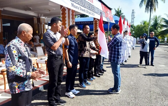 SERAHKAN BENDERA : Wakil Bupati Barito Utara Sugianto Panala Putra didampingi Sekda Muhlis dan beberapa kepala perangkat daerah menyerahkan bendera merah putih kepada Camat Teweh Tengah Jati Prayogo di halaman Kantor Bupati Barito Utara, Minggu (30/7).