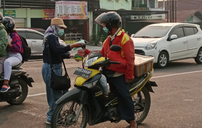 PEDULI KESEHATAN: Pihak Dinas Kesehatan Kota Palangka Raya membagikan masker kepada pengendara di perempatan Jalan Tjilik Riwut-Antang, Jumat (29/9). ILHAM ROMADHONA/KALTENG POS