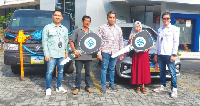 HADIAH UTAMA : Pemimpin BRI Cabang Palangka Raya Sari Wahono (tengah) saat menyerahkan hadiah utama kepada dua pemenang di halaman BRI Cabang Palangka Raya, Kamis (21/12).