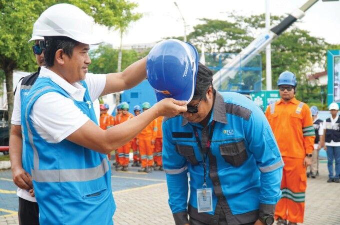 SIMBOLIS : General Manager PLN UID Kalselteng Muhammad Joharifin memasang APD kepada petugas siaga Pelayanan Teknik (Yantek), belum lama ini.