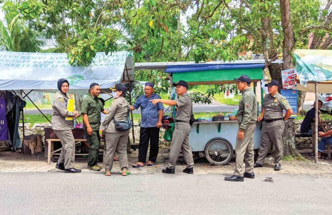 PEMBINAAN : Anggota Satpol PP Palangka Raya saat menyosialisasi PKL yang berjualan di bahu jalan sekitar Jalan Raden Saleh, Kota Palangka Raya, Senin (29/1).