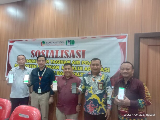 KEBERSAMAAN: Salah satu pelanggan PDAM Katingan menunjukkan bukti transaksi pembayaran menggunakan aplikasi Betang Mobile Bank Kalteng, didampingi Pimpinan Bank Kalteng Cabang Kasongan Hendra Loren, tim dari Kantor Pusat Bank Kalteng Empas S Umar, Direktu