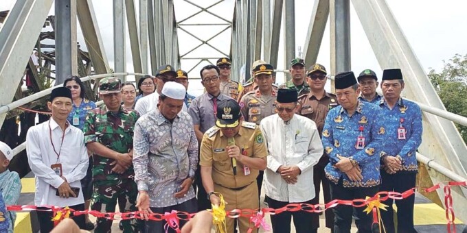 Pj Bupati Kapuas Erlin Hardi, ST, disaksikan Anggota DPRD Kabupaten Kapuas Ahmad Baihaqi dan Forkopimda, serta Kepala Dinas PUPRPKP Kabupaten Kapuas Drs. Yan Hendrie Ale, memotong pita tanda peresmian Jembatan Pasar Senin Anjir Serapat Tengah, Senin (3/6/