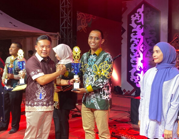 MENYERAHKAN : Sekretaris Daerah Kabupaten Sukamara, Rendy Lasmana saat menyerahkan hadiah pada malam penutupan Sukamara Expo 2024, di Taman Permata Sukma, belum lama ini.