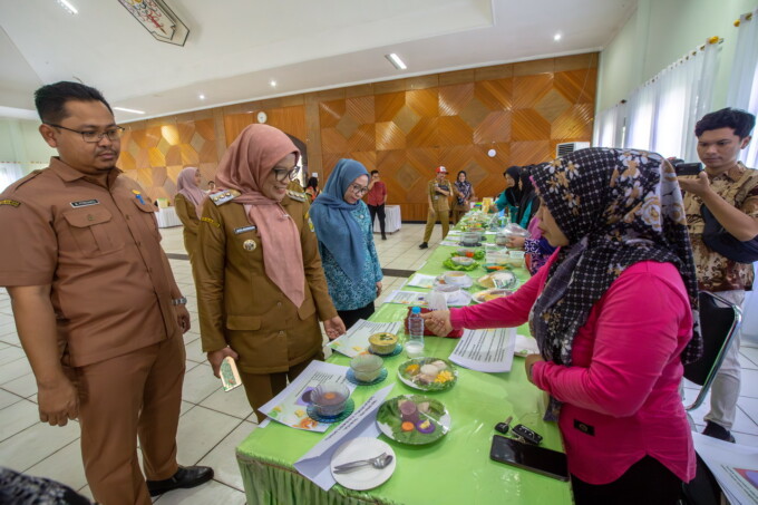 MAKANAN DASHAT: Pj Wali Kota Palangka Raya Hera Nugrahayu meninju hasil makan olahan dari kegiatan orientasi Dashat, di Gedung Palampang Tarung, Selasa (23/7/2024).