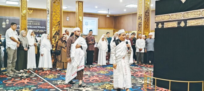 PRAKTIK : Pembimbing menjelaskan tata cara selama umrah kepada jemaah lalu memperagakan cara pemasangan kain untuk jemaah pria di Kota Palangka Raya, Sabtu (13/7).