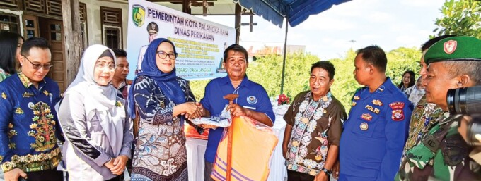 SERAH TERIMA : Pj Wali Kota Palangka Raya Dr Hera Nugrahayu MSi (tiga dari kiri) didampingi Kepala Dinas Perikanan Palangka Raya Ir Indriarti Ritadewi MAB (dua dari kiri) saat menyerahkan bantuan kepada Pokmaswas, di sekitar Dermaga Petuk Ketimpun, Kamis