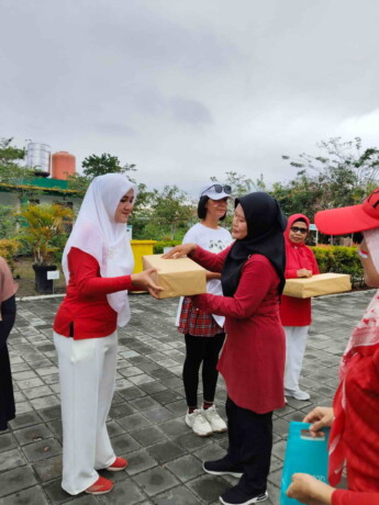 Kasi Kesos Kelurahan Panarung Sri Lestari (kerudung hitam) saat memberikan hadiah doorprize pada warga peserta senam yang beruntung