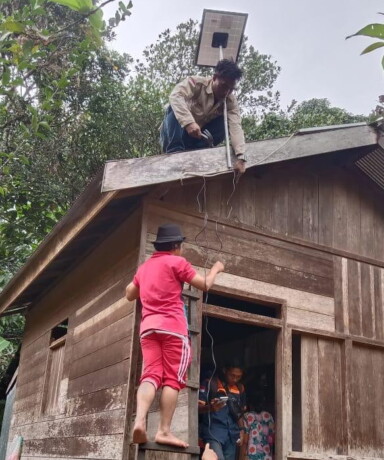MENYALA: Proses pemasangan PLTS program Gubernur Kalteng Sugianto Sabran di desa terpencil.