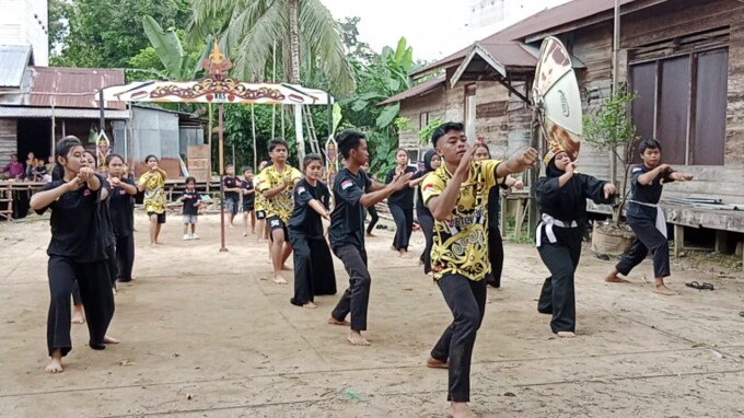 DESA JUARA: Kades Telaga Tomie didampingi istri memperlihatkan trofi juara I Lomba Desa Ketegori Kewilayahan Tingkat Kalteng di Kantor Gubernur Kalteng, beberapa waktu lalu. Desa ini begitu peduli melestarikan kesenian dan budaya lokal seperti pencak sila