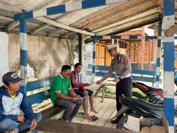 TINGKATKAN KESADARAN: Personel Satlantas Polres Mura membagikan leaflet berisi imbauan untuk tertib berlalu lintas kepada masyarakat di pangkalan ojek Kota Puruk Cahu, Minggu (27/10/2024
