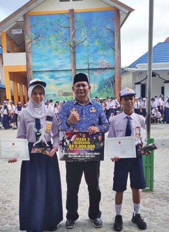 Salah satu atlet tenis junior asal SMPN-2 Kota Palangka Raya, Yasmin Aribi Putri saat foto bersama Kepala Sekolah SMPN-2 Kota Palangkaraya H. Muhammad Ahmadi, S.Pd beberapa waktu lalu.