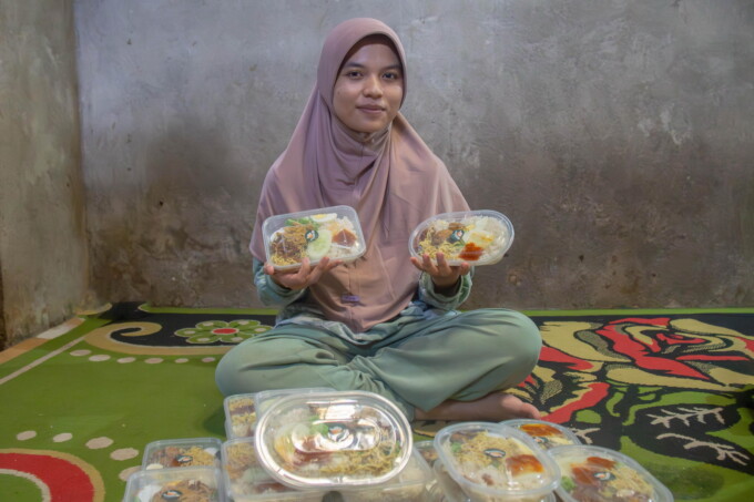 USAHA KULINER: Alfisah bersama Akmal memperlihatkan nasi uduk yang sudah dikemas untuk dijual.