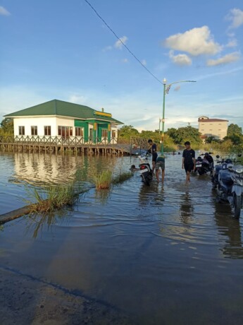 BENCANA ALAM: Kondisi jalan menuju Puskesmas Pahandut Seberang terendam banjir, Minggu (1/12). 