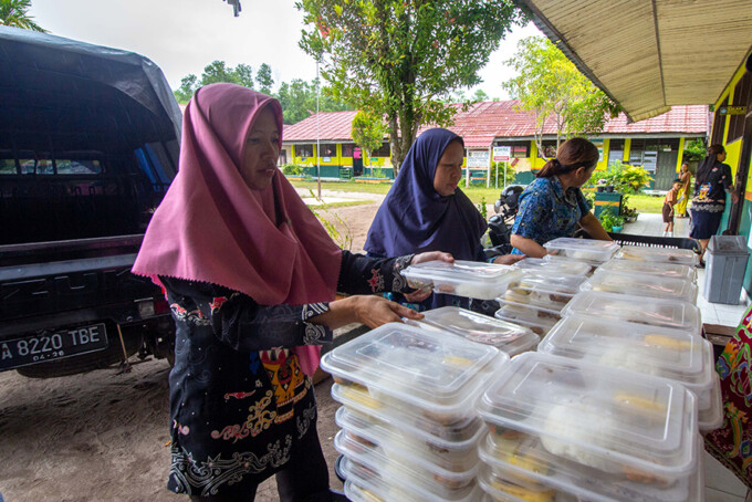 Para guru menyusun paket makan bergizi gratis sebelum dibagikan kepada murid-murid SDN 7 Palangka. ARIEF PRATHAMA/KALTENG POS