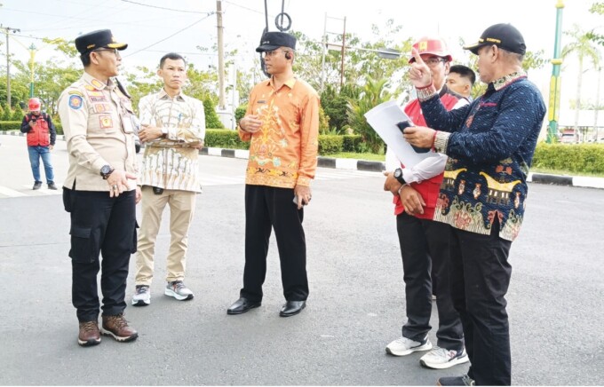 PENERTIBAN: Kasatpol PP Kota Palangka Raya Berlianto saat berkoordinasi dengan Pj Wali Kota Palangka Raya Akhmad Husain dalam kegiatan penertiban baleho dan reklame di sekitar bundaran kecil Palangka Raya, Kamis (16/1).