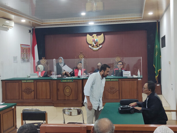 Terdakwa Hendra berdiskusi dengan penasihat hukumnya setelah eksepsi yang diajukannya ditolak majelis hakim PN Palangka Raya, Selasa (11/2/2025). ARIEF PRATHAMA/KALTENG POS