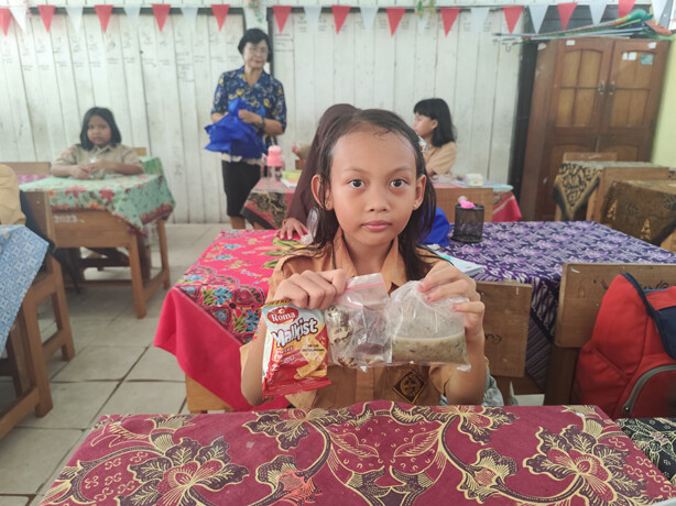 Murid SDN 11 Palangka menunjukkan menu miliknya pada program makan bergizi gratis di bulan puasa. NOVIA/KALTENG POS