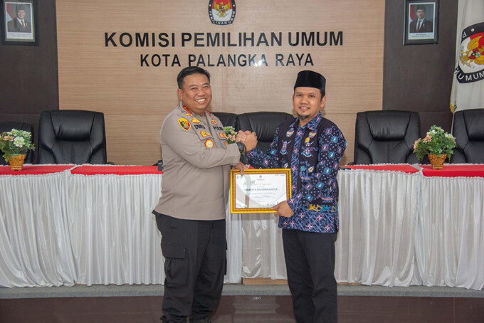 Joko anggoro memberikan piagam penghargaan apresiasi terlaksana pemilihan Wali kota dan Wakil Wali Kota kepada Kapolresta Palangka Raya, Kombes Pol Dedy Supriadi di Aula RPP KPU Kota Palangka Raya, Jumat (28/2/2025). ARIEF PRATHAMA/ KALTENG POS