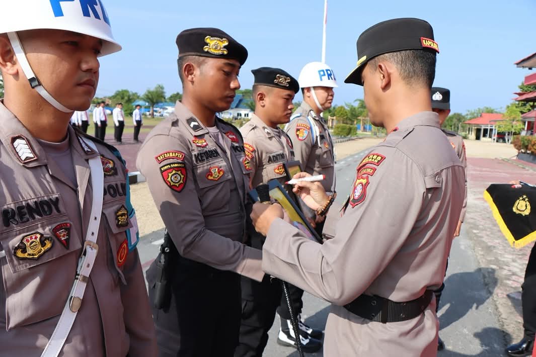 AKHIR KARIR: Kapolres Katingan AKBP Chandra Ismawanto mencoret dua foto anggota Polri yang diberhentikan. HUMAS