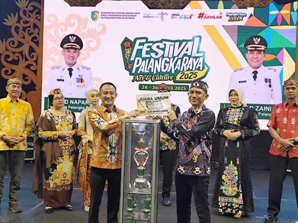  Wali Kota Palangka Raya Fairid Naparin menyerahkan trofi juara umum kepada Camat Pahandut Said Zain Bachsin, saat penutupan Festival Palangka Raya di halaman Kantor Wali Kota Palangka Raya, Sabtu malam (26/4/2025).MUTOHAROH/KALTENG POS