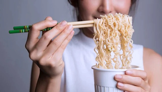 Ilustrasi perempuan makan mie.