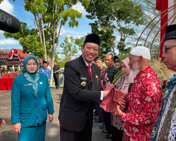 MENYERAHKAN : Bupati Sukamara, Masduki, saat menyerahkan tali asih kepada pensiunan usai Apel Hari Pendidikan Nasional, di halaman kantor Bupati Sukamara, Jumat (2/5/2025). NURHALIZA/KALTENG POS