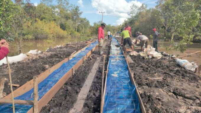 PERSIAPAN COR JALAN : Satgas TMMD saat melakukan pemasangan plastik cor beton di Desa Talio.
