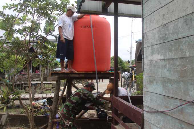 PASANG TANDON AIR : Satgas TMMD bersama warga memasang tandon air untuk mushola di desa Talio.