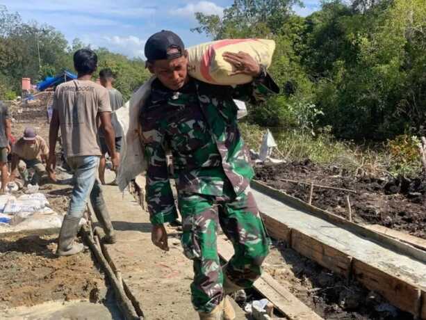 PEKERJAAN JALAN : Satgas TMMD saat memikul semen,guna percepatan pekerjaan jalan di Desa Talio.