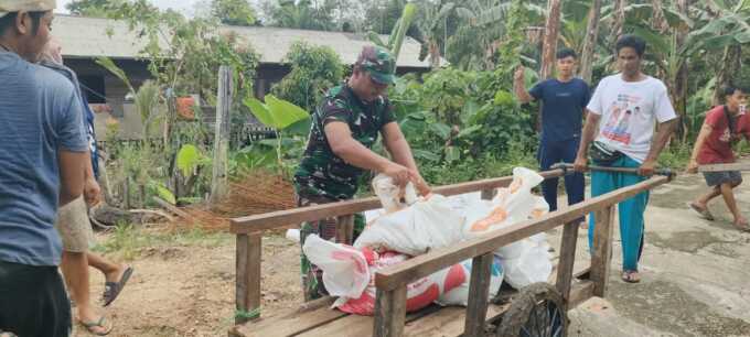 Satgas TMMD bersama warga Desa Talio gotong royong mengangkut material jenis pasir dan batu.