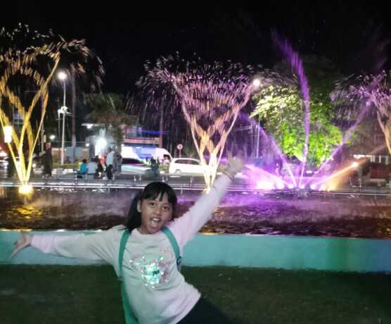 Seorang anak berfoto di depan air mancur di Bunbes Palangka Raya.