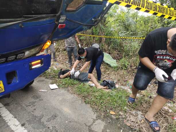 Petugas Polsek Dusun Tengah bersama warga saat mengevakuasi jenazah sopir truk yang ditemukan tewas di pinggir jalan Desa Unsum, Rabu (17/6).