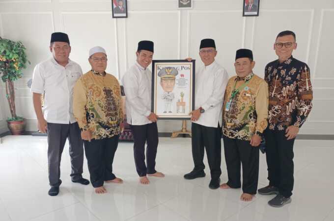 Direktur PT Kalteng Pos Press Dr H Wahyudie F Dirun menyerahkan karikatur kepada Bupati Pulang Pisau H Ahmad Rifa