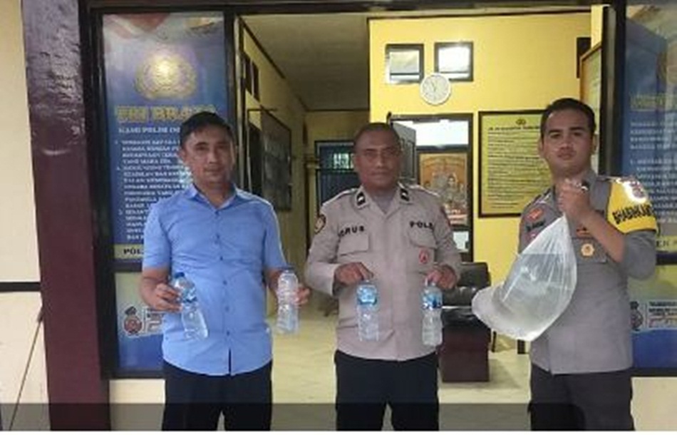 Aparat Polsek Mananggu saat mengamankan puluhan liter miras cap Tikus.(hms-pol)