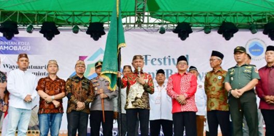 Bupati Pohuwato, Saipul A. Mbuinga menerima pataka dari Wakil Wali Kota Kotamobagu, Nayodo Koerniawan,SH pada acara Festival Seni Budaya Jaton (Fesbujaton) XVII se-Indonesia Timur (hmskab)
