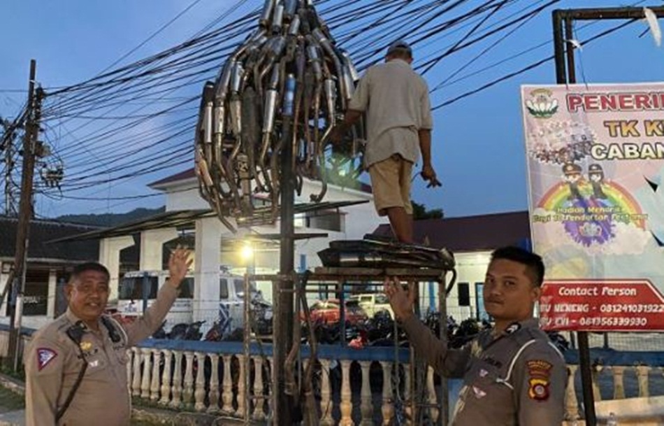 59 buah Knalpot brong hasil sitaan Satlantas Polresta Gorontalo Kota Pada Operasi Patuh Otanaha 2023 disulap menjadi Tugu Knalpot Nampak KBO Lantas Polresta AKP Hot Pilat saat di lokasi tugu.(hms-pol