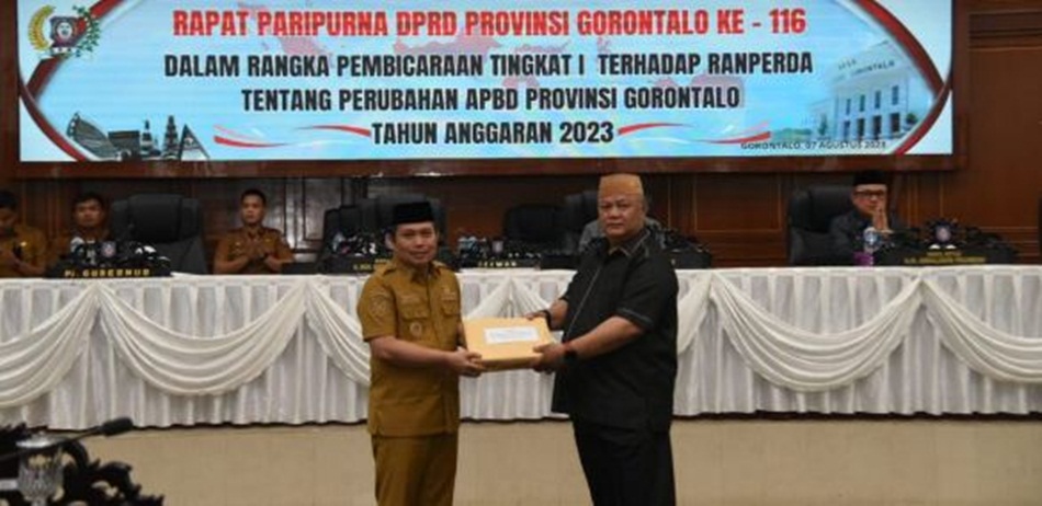 Penjagub Gorontalo Ismail Pakaya saat menyerahkan naskah Ranperda Perubahan APBD tahun 2023 kepada Wakil Ketua DPRD   Provinsi Gorontalo Kris Wartabone, pada Rapat Paripurna DPRD ke-116 , Senin (7/8/)