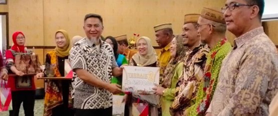 Penjabat Sekdaprov Gorontalo Budiyanto Sidiki saat menyerahkan hadiah kepada pemenang lomba desa lokus tengkes berbasis Germas, usai membuka kegiatan Pertemuan Implementasi Kebijakan Germas (F:winda)
