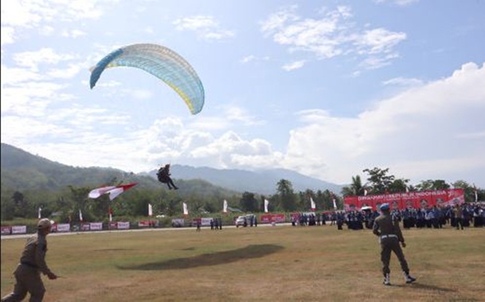 Penampilan atlet atraksi paralayang dari Wisata Bukit Arang menuju Stadion Bone Bolango turut memeriahkan dan menyemarakkan perayaan HUT ke-78 Kemerdekaan RI di Bone Bolango. (F.AKP/Diskominfo)